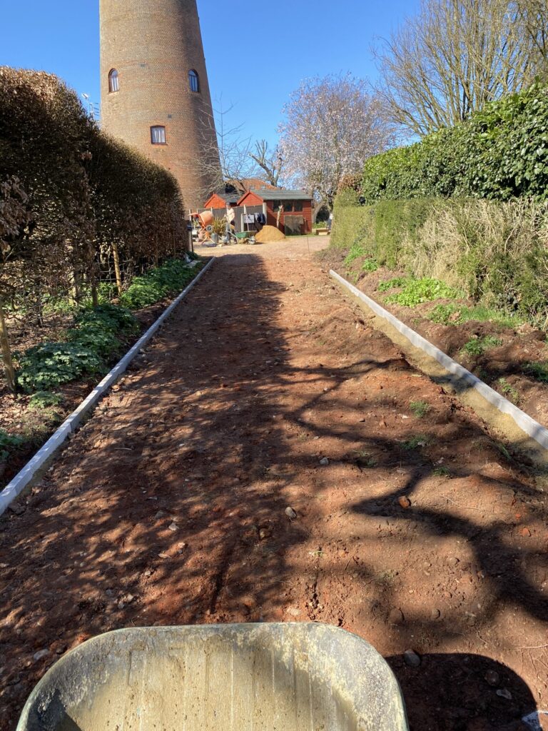 Private roadway for Aylsham Windmill with new concrete edging kerbs, hardcore base and wheelbarrow ready for tarmac