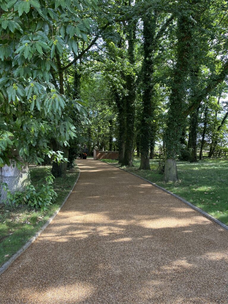 tar and chip surface on a private roadway with kerb edging surrounded by woods on a country private road