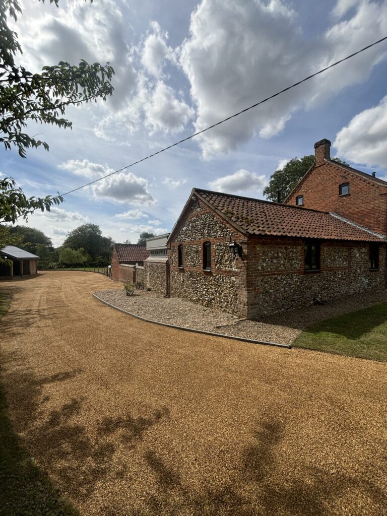 a new tar and chip driveway with a kerb edging on a country property in north tuddenham, norfolk