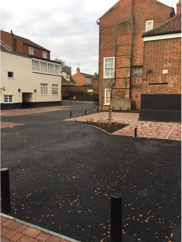 Tarmac car park in Norwich with permeable brick weave parking bays