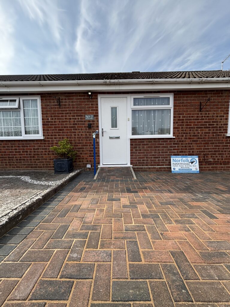A house with a brick exterior and block paved paved driveway featuring a wheelchair friendly front door ramp